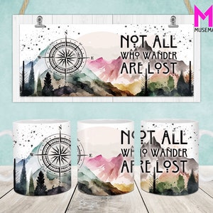May include: White ceramic mug with a watercolor design featuring a compass, mountains, and the text "NOT ALL WHO WANDER ARE LOST." The design includes shades of blue, pink, and green.