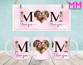 Puede incluir: Dos tazas rosas con un diseño de corazón blanco con una foto de una madre y su hija. Las tazas tienen la letra "M" y las palabras "Te quiero" impresas.