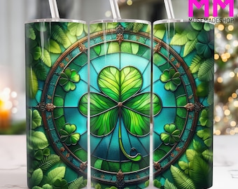 May include: Three stainless steel tumblers with a green shamrock design. The shamrock is surrounded by a stained glass pattern with blue, green, and gold accents. The tumblers are surrounded by green leaves.