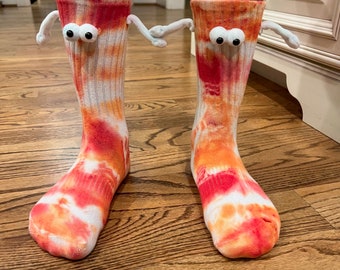 Adult one-size hand holding tie-dyed socks. Made by an 11 year old entrepreneur starting out on his business journey.