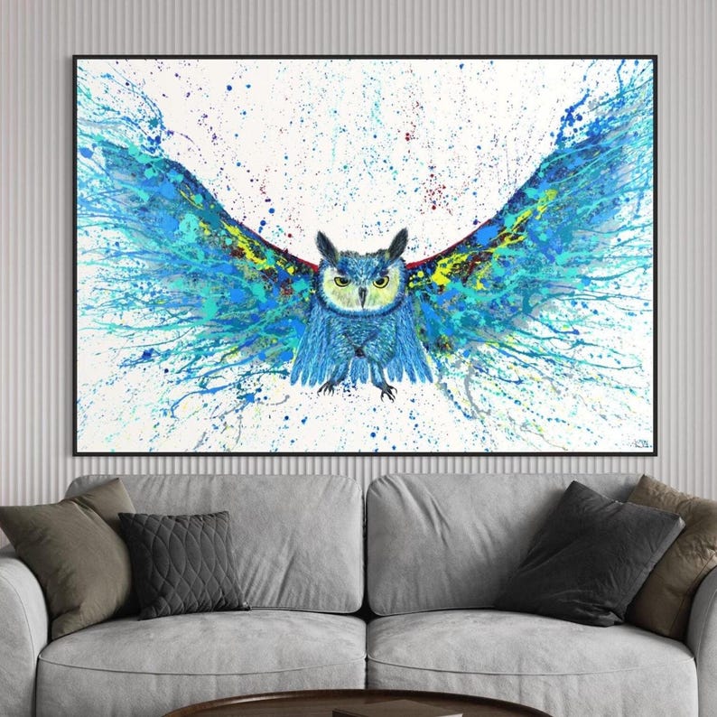 Abstract blue owl flying forward with wide open wings splashed in vibrant blue and yellow tones on a white background, printed on canvas.