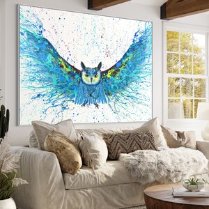 May include: A blue and green owl with its wings spread wide, painted in a splatter style on a white background.