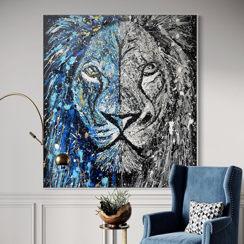 Abstract lion head painting on canvas, split between vibrant blue and monochrome black and white, with dynamic splashes of paint and bold texture.