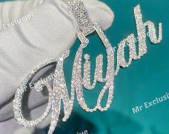 May include: A silver pendant spelling "Miyah" in a cursive font, encrusted with sparkling crystals. The pendant is held against a white surface, with the words "Mr Exclusive" visible in the background.