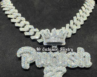 May include: A silver chain necklace with a large diamond-encrusted pendant that says "Pusha" with a crown on top. The pendant is surrounded by smaller diamonds. The text "Mr Exclusive Jewelry" appears twice on the image.
