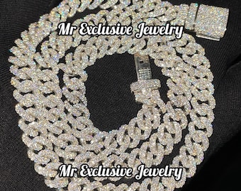 Op de afbeelding: Een zilveren ketting met een grote, met kubische zirkonia bezette sluiting. De ketting is gemaakt van kleine, in elkaar grijpende schakels en is bedekt met kleine, glinsterende stenen. De tekst "Mr Exclusive Jewelry" staat twee keer op de afbeelding.
