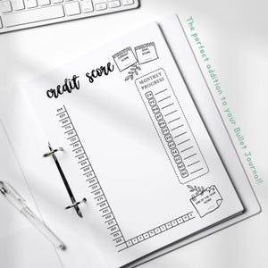 May include: A white paper credit score tracker insert for a binder featuring a vertical scale from 300 to 850, a monthly progress section with abbreviations for months, and boxes labeled current score, goal score, and end of the year score.