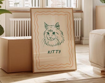 Könnte beinhalten: Ein gerahmter Kunstdruck mit einer grünen Strichzeichnung eines Katzenkopfes und dem Wort "KITTY" darunter. Das Kunstwerk hat einen orangefarbenen Rand und ist vor einem hellbeigen Hintergrund platziert. Im Hintergrund befindet sich ein brauner Karton.