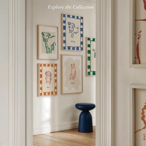May include: A selection of framed dog art prints in different sizes and colours, including green, blue, and orange. The prints feature simple line drawings of dogs. The text "Explore the Collection" is at the top.