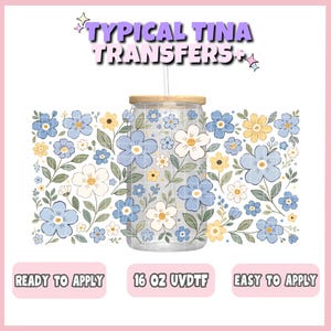 Könnte beinhalten: Ein durchsichtiger Glasbecher mit Holzdeckel und Strohhalm, verziert mit einem Blumenmuster in Blau, Weiß und Gelb. Der Text "TYPICAL TINA TRANSFERS+" steht oben. Der Becher ist mit "16 OZ UVDTF" und "READY TO APPLY" und "EASY TO APPLY" beschriftet.