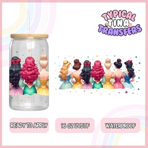Könnte beinhalten: Ein 473 ml klarer Becher mit Bambusdeckel und Strohhalm. Der Becher zeigt ein Design mit sieben Prinzessinnen von Disney, die dem Betrachter den Rücken zukehren. Die Prinzessinnen tragen bunte Kleider und haben langes Haar. Das Design ist von Sternen und Glitzer umgeben. Der Text "Typical Tina Transfers" befindet sich in der oberen rechten Ecke des Bildes. Der Text "Ready to Apply", "16 oz UVDTF" und "Waterproof" befindet sich am unteren Rand des Bildes.