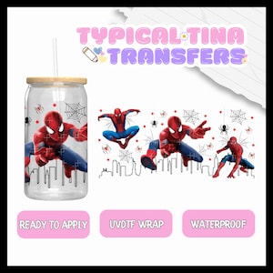 May include: A clear glass tumbler with a straw and a red and blue Spiderman design. The design includes a cityscape, spiderwebs, and stars. The tumbler is labeled "Ready to Apply", "UV/DT Wrap", and "Waterproof".