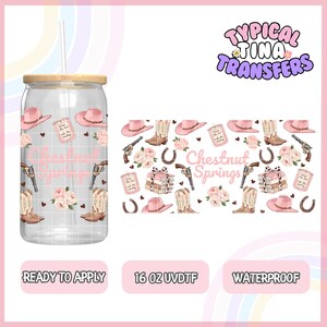 May include: A clear glass can-shaped tumbler with a bamboo lid and straw. The tumbler features a pink and brown Western-themed design with cowboy hats, boots, roses, and the text "Chestnut Springs". The design includes a 16 oz UVDTF label.