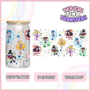 Può includere: Un bicchiere trasparente da 473 ml con coperchio in bambù e cannuccia. Il bicchiere ha un design con personaggi di Sailor Moon e stelle. Il design è pronto per essere applicato ed è impermeabile. Il testo "Typical Tina Transfers" è nell'angolo in alto a destra dell'immagine.