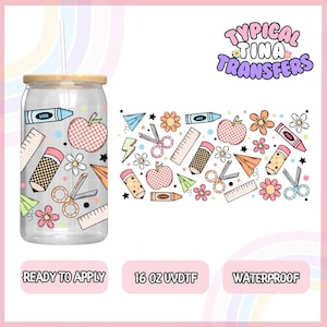 Puede incluir: Un vaso transparente de 473 ml con tapa de madera y una pajita. El vaso tiene un diseño de útiles escolares, incluyendo lápices, crayones, tijeras, reglas, manzanas y flores. El diseño está en una variedad de colores, incluyendo rosa, azul, amarillo y verde. El vaso está listo para aplicar y es impermeable. El texto "Typical Tina Transfers" está en la esquina superior derecha de la imagen.