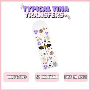 May include: A white, rounded-top 5.2 bookmark featuring a repeating pattern of black dragons, purple flowers, yellow moons, stacks of books, daggers, potion bottles, and scrolls with text. The design includes small orange flames and stars.