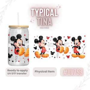 May include: A clear glass tumbler with a wooden lid and a straw. The tumbler has a design of Mickey Mouse in red, yellow, and black on a white background with red stars. The tumbler is ready to apply a UV DTF transfer. The image also shows three separate images of Mickey Mouse in different poses.