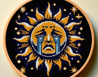 Op de afbeelding: Een ronde borduurring met een zwarte achtergrond en een gele zon met een huilend gezicht in het midden. De zon wordt omringd door witte sterren op een donkerblauwe achtergrond.