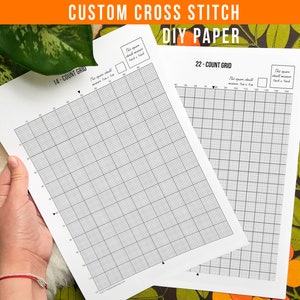May include: Two sheets of DIY cross stitch paper with grid patterns. One sheet is labeled "14-COUNT GRID" and the other "22-COUNT GRID". The top of the image has the text "CUSTOM CROSS STITCH DIY PAPER". The paper is white with black grid lines.