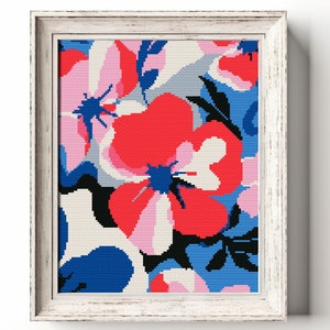 Puede incluir: Una obra de punto de cruz enmarcada que presenta un patrón floral colorido con flores rosas, rojas, azules y blancas. Las flores son estilizadas y abstractas, con un diseño moderno.