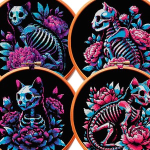 May include: Four embroidery hoops with black fabric and colorful cross-stitch designs of cat skeletons surrounded by pink and blue flowers.
