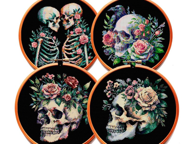 May include: Four circular wooden embroidery hoops containing cross-stitch designs on black fabric. The designs feature human skulls, skeletons, and colorful floral arrangements including pink and white roses, green leaves, and a dark bird.