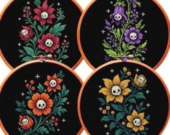 May include: Four circular wooden embroidery hoops containing black fabric with cross-stitched floral designs. Each flower features a small white skull at its center, surrounded by green leaves, berries, and small white cross-shaped star accents.