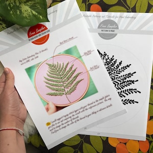 K&ouml;nnte beinhalten: Zwei druckbare Stickmuster, eines mit einem gr&uuml;nen Farnmuster in einem Reifen und das andere mit einem schwarzen Farnmuster. Der Text "Free Sampler" ist auf beiden Seiten sichtbar.