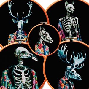 May include: Five embroidery hoops with black backgrounds and colorful floral patterns. Each hoop features a different animal skeleton wearing a suit, including a deer, a cat, a dog, a bird, and a moose.
