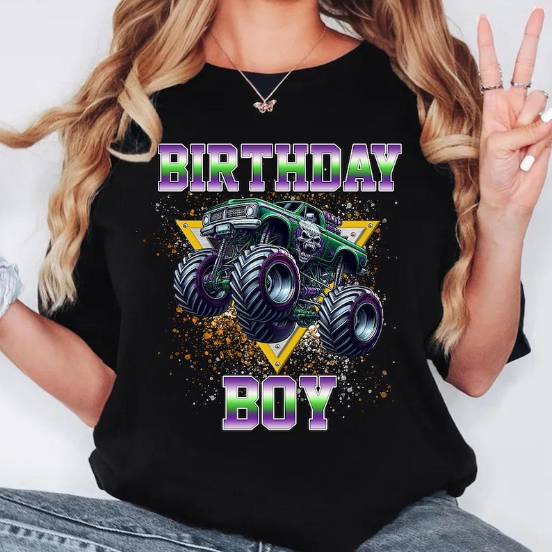 May include: Black t-shirt with a green monster truck graphic and the text "Birthday Boy" in purple and green letters.