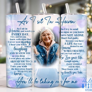 May include: A white tumbler with a blue and purple watercolor background. The tumbler features a photo of an older woman with a quote that reads "As I sit in Heaven and watch you every day. I try and let you know with signs that I never went away. I hear you when you're laughing and watch you as you sleep. I even place my arms around you to calm you as you weep. I see you wish the days away begging to have me home, You'll be taking on for me. So I try to send you signs so you know you're not alone. Don't feel guilty because you have a life that was denied to me. Heaven is truly beautiful just you wait and see. So live your life, laugh again, enjoy yourself and be free. Then I know with every breath you take."