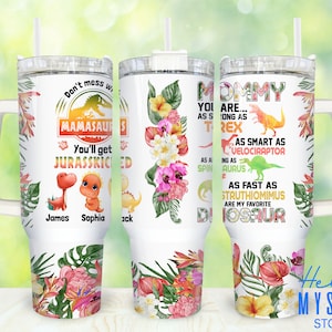 May include: A white tumbler with a floral design and a dinosaur theme. The text on the tumbler reads "Don't mess with Mamasaurs You'll get Jurassic-kicked" and "Mommy you are as strong as T-Rex as smart as Velociraptor as fast as Struthiomimus are my favorite Dinosaur".