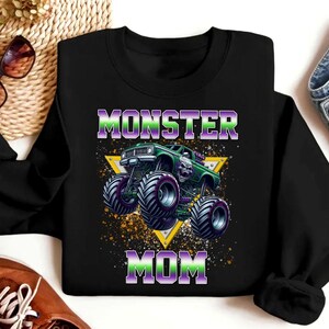 May include: Black sweatshirt with a green monster truck graphic and the text "Monster Mom" in purple and green.