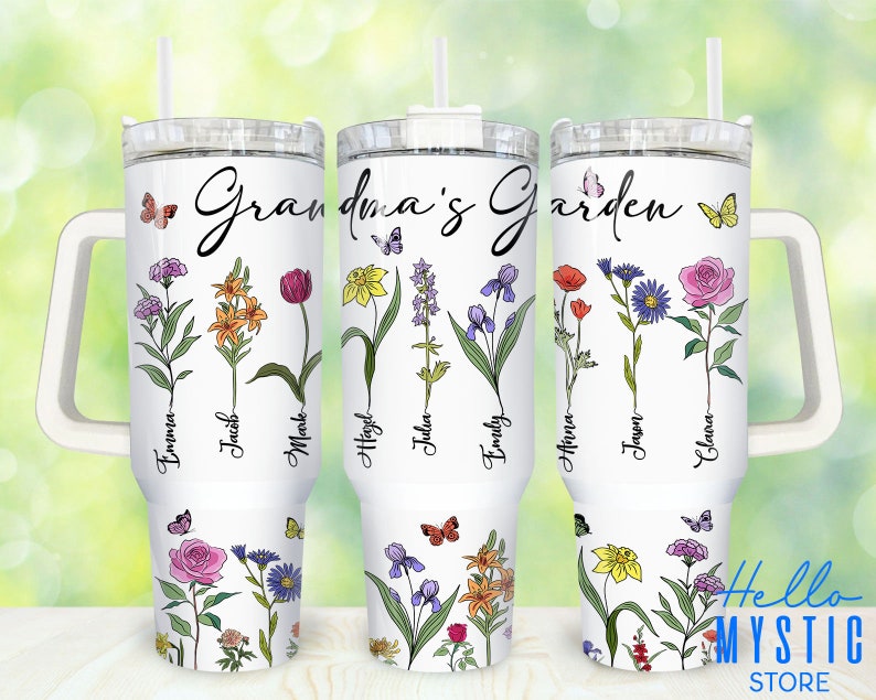 Może przedstawiać: Biały kubek ze stali nierdzewnej z uchwytem i słomką. Kubek ma kwiatowy wz&oacute;r z motylami i tekstem "Grandma's Garden".  Imiona Emma, Jacob, Mark, Hayley, Julia, Emily, Anya, Jayden i Eleanor są napisane pionowo na kubku.