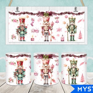 May include: White ceramic mugs and a framed print featuring a festive design. The artwork showcases watercolor illustrations of nutcrackers in red, green, and pink, along with floral and holiday-themed elements. The mugs and print are displayed on a light wood surface.