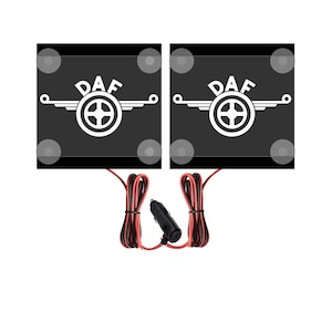 May include: Two black square car seat warmers with the DAF logo in white. The warmers have a black cord with a cigarette lighter plug.