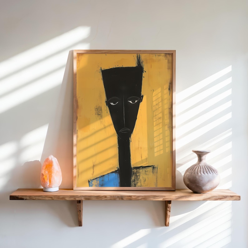 May include: A framed rectangular wall art print featuring a stylised, elongated black figure with a flat-top head against a vibrant yellow background. The figure has a long neck and a blue lower section. The artwork is displayed in a light wood frame.