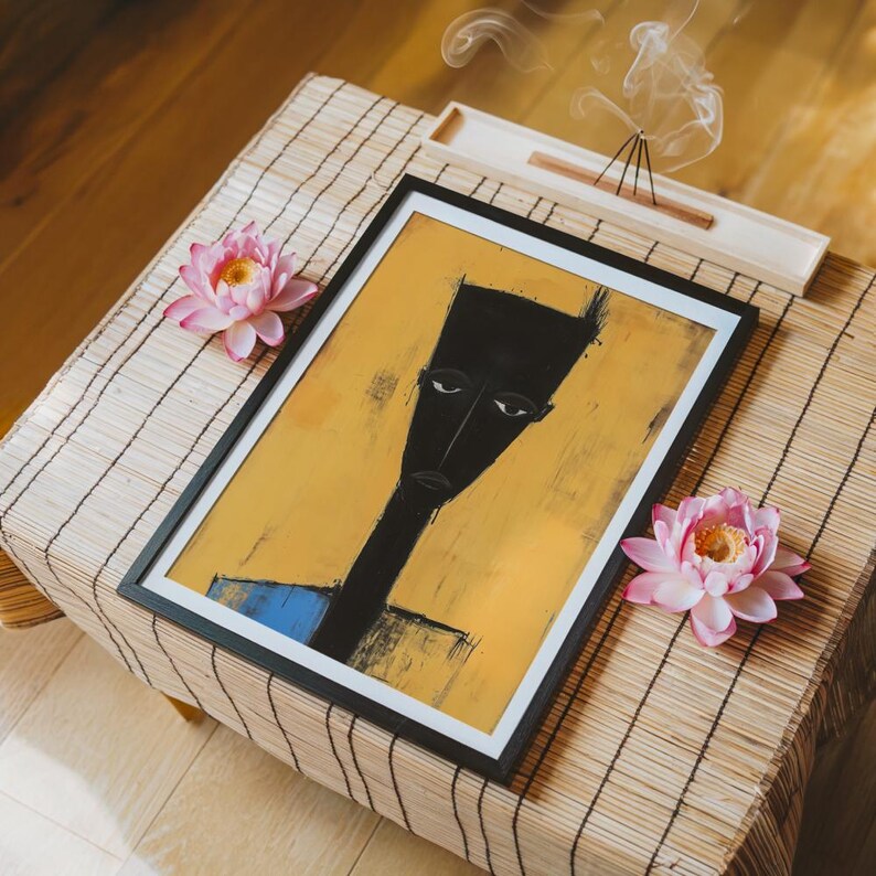 May include: A framed rectangular art print featuring a stylised black silhouette of a person with an elongated head and neck against a mustard yellow background, with a small blue rectangular accent at the bottom edge of the figure's torso.