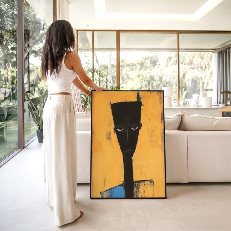 May include: A rectangular framed painting featuring a stylised, elongated black figure with white eyes against a vibrant yellow background. The figure has a long neck and a flat-topped head, with a small blue section visible at the bottom edge.