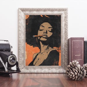 May include: A framed illustration of a woman with an afro, wearing a black top, and smoking a cigar. The background is orange and the frame is silver.