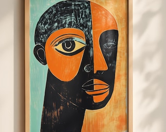May include: A framed print featuring a stylized portrait of a face divided into two distinct color sections. One side is set against a light blue background with black and orange tones, while the other side features an orange background with black.