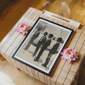 May include: A framed monochromatic art print depicting four figures standing in a row, each wearing a dark suit. The print is displayed on a textured surface alongside two pink lotus flowers and a wooden incense holder with rising smoke.