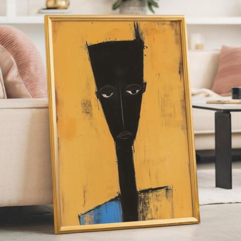 May include: A framed vertical wall art piece featuring a stylised, elongated black figure against a textured mustard yellow background. The figure has a flat-topped head, almond-shaped eyes, and a blue rectangular section at the base of the neck.