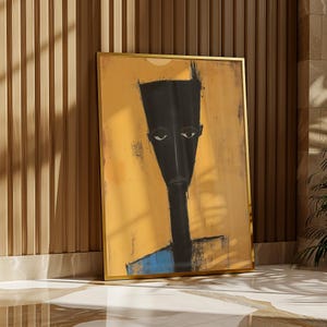 May include: A framed vertical wall art print featuring a stylised, elongated black figure with a flat-topped head and narrow eyes set against a textured mustard yellow background, with a small blue section at the bottom of the figure's torso.