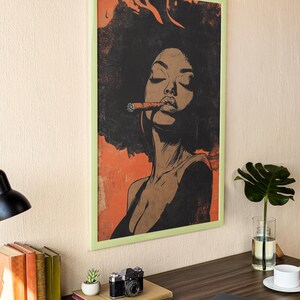 May include: A framed illustration of a woman with an afro hairstyle, wearing a low-cut top and smoking a cigar. The background is a textured orange color.