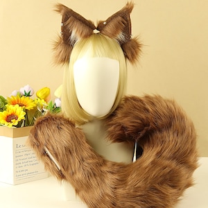 Può includere: Un set di fascia e coda con orecchie da gatto in finta pelliccia marrone. La fascia presenta orecchie dritte con una consistenza soffice e piccoli abbellimenti. La coda è lunga e folta, progettata per essere indossata intorno alla vita.