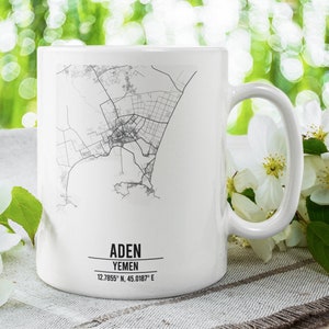 May include: White ceramic mug with a black and white map of Aden, Yemen printed on it. The mug has a handle and the text "Aden, Yemen 12.7855° N, 45.0187° E" is printed on the bottom.