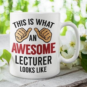 Könnte beinhalten: Weiße Keramik-Kaffeetasse mit einem schwarzen und roten Design, auf dem "Das ist, wie ein großartiger Dozent aussieht" steht, mit zwei Daumen hoch-Emojis.