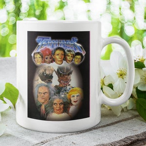 Puede incluir: Taza de cerámica blanca con una imagen en blanco y negro del elenco del programa de televisión de los años 80 "La Familia Addams". La imagen incluye los personajes Lily, Herman, Grandpa, Eddie y Marilyn.