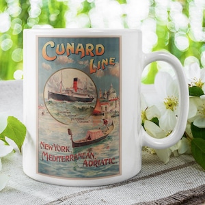 Peut inclure: Mug en céramique blanche avec une publicité de voyage vintage de la Cunard Line. Le design comprend un navire, une gondole et le texte "New York, Méditerranée, Adriatique". Le mug est posé sur un fond vert flou.